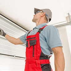 Person inspecting garage door mechanism